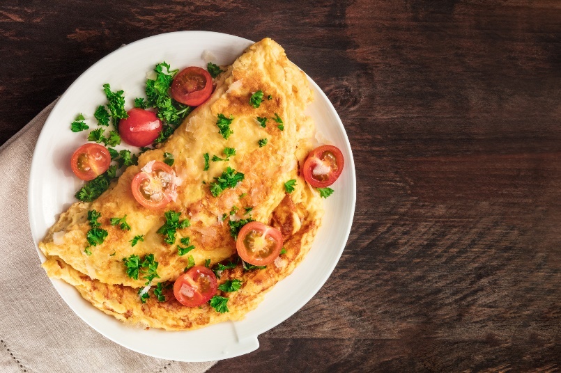 Pikantu brokastu piemērs: olu omlete ar zaļumiem un svaigiem dārzeņiem.