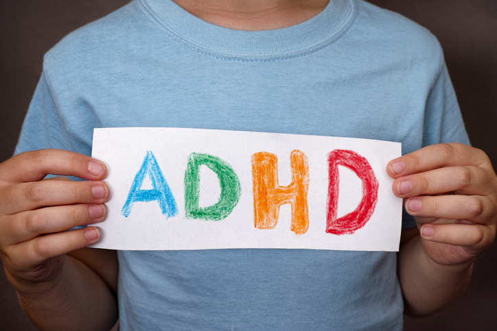 Zēns tur zīmi ar krāsainu ADHD zīmi